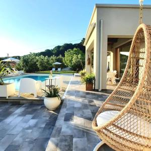 费拉约港La Suite con Piscina Privata的一个带游泳池的庭院,配有摇摆藤椅