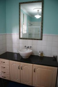逊邱伦Hampton House Guest House的一间带水槽和镜子的浴室