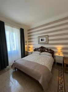 斯培西亚Affittacamere Perla del Prione的一间卧室设有一张带条纹墙的大床