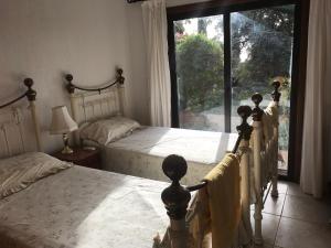 珊瑚湾Villa Manzanillo的一间卧室设有两张床和大窗户