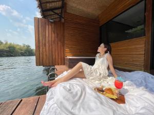 崇贞夫The Hub Erawan Resort的坐在船上的穿着白色衣服的女人