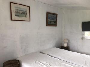Les Chalets de Babeth et Cathy的卧室配有一张床,墙上挂有两张照片