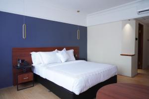 雅加达Stay 'd Kuningan的一间卧室设有一张大床和蓝色的墙壁