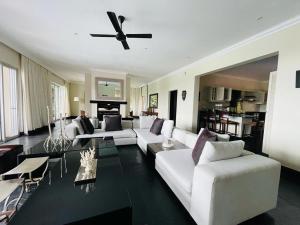 彭宁顿Villa Umdoni的客厅配有白色沙发和吊扇