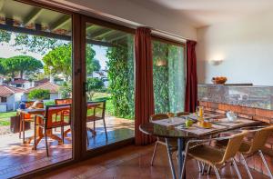 塔维拉佩德拉德莱酒店的用餐室设有滑动玻璃门和桌椅