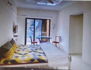 浦那2 BHK flat with Kitchen and Free Wi Fi Kharadi,Pune的一间卧室配有一张床和一张桌子及椅子