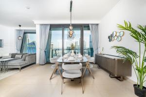 迪拜Gorgeous 2BR Apartment in Burj Vista Tower 1 Downtown Dubai by Deluxe Holiday Homes的一间带桌子和沙发的用餐室