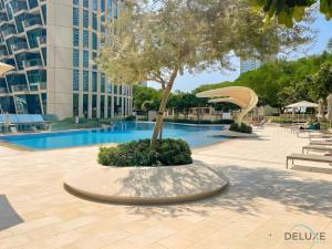 迪拜Gorgeous 2BR Apartment in Burj Vista Tower 1 Downtown Dubai by Deluxe Holiday Homes的游泳池旁的树圈里