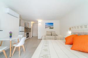 奥尔比亚Brorent Affittacamere moro dream的白色的客房配有一张床、一张桌子和椅子