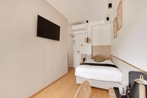巴黎Maison Urbaine的一间卧室配有一张床,墙上配有电视