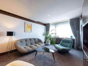 里昂索菲特里昂贝勒库尔酒店的客厅配有沙发和椅子