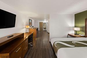 康瑟尔布拉夫斯Quality Inn & Suites near I-480 and I-29的配有一张床和一台平面电视的酒店客房
