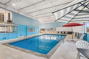 康瑟尔布拉夫斯Quality Inn & Suites near I-480 and I-29的大楼内一个带红伞的大型游泳池