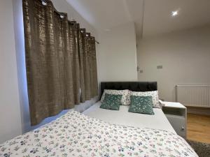 LewishamSmart Cosy/Small Double Room in Oakridge Road Bromley的一间卧室配有一张带绿色枕头的大床