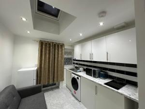 LewishamSmart Cosy/Small Double Room in Oakridge Road Bromley的厨房配有白色橱柜和一台洗衣机