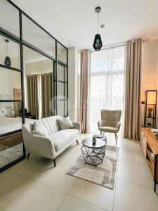 迪拜Luxurious 1BR in Socio Tower Dubai Hills Estate的带沙发和椅子的大客厅