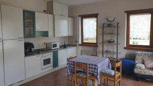 托尔博莱Appartamenti Nido d'Aquila的厨房配有白色橱柜和桌椅