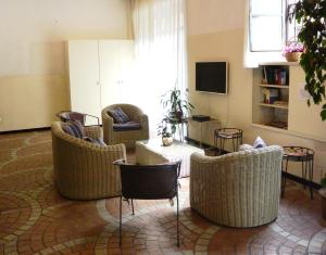 米兰奈图尔诺酒店的客厅配有藤椅和电视