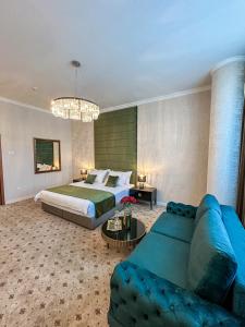 巴尼亚卢卡维多维奇酒店的一间卧室配有一张床和一张蓝色的沙发