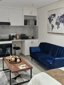 德班Glorystar The Millennial Umhlanga的客厅配有蓝色的沙发和桌子
