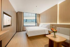 宝安瑞希酒店(深圳宝安国际机场店)的酒店客房配有一张床铺和一张桌子。