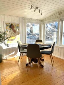 斯沃尔韦尔Hytte i Svolvær的一间带桌椅和窗户的用餐室