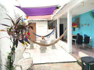 累西腓Lê'Frevo Pernambucano Hostel的客房设有吊床和桌椅。