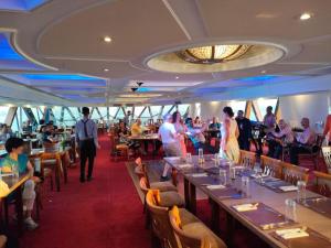 阿斯旺Nile Cruise Luxor Aswan 3,4 and 7 nights的游轮上的餐厅,有人坐在桌子上