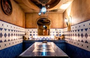 Kromerowo亚泽东方SPA&康体酒店的厨房铺有蓝色和白色的瓷砖,配有桌子