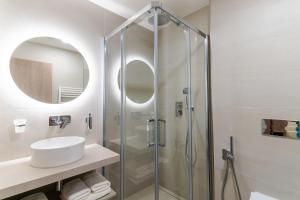 利托斯基简Spa & Wellness Hotel Fitak****的一间带玻璃淋浴和水槽的浴室