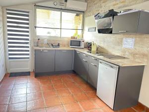 科利尤尔appart central et son parking privatif gratuit的厨房配有灰色橱柜和台面