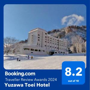 汤泽町汤泽东映酒店 的山前的雪中酒店