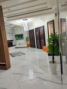NnewiPassready Hotel and Suites Nnewi的大堂的门和地板上的盆栽植物