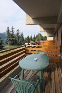 奥尔西埃Résidence Horizon I - Pièces 954的木制甲板上的蓝色桌子和椅子