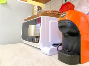 奇亚Torre di Chia Holiday Home的厨房柜台配有微波炉和咖啡机