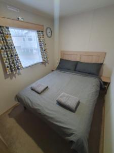 Lytchett MinsterEscape City Caravan的一间卧室配有一张大床和两条毛巾