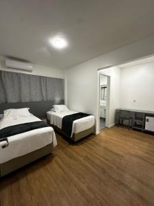 大坎皮纳Hotel do Vale的酒店客房,设有两张床和镜子