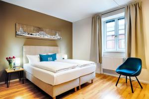 柏林martas Hotel Berlin-Mitte的一间卧室配有一张床和一张蓝色椅子