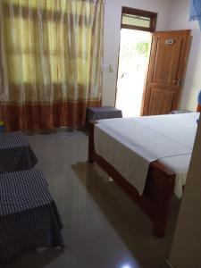 波隆纳鲁沃Udesh Guest的一间卧室配有一张床、两把椅子和一个窗户