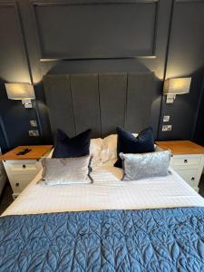 罗斯林十字架教堂旅馆的一间卧室配有一张带蓝色枕头的大床