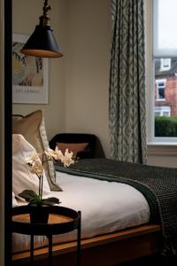林肯Brayford House的一间卧室配有一张带桌子和台灯的床