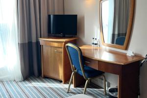 希灵登Colnbrook Hotel London Heathrow Airport的客房设有一张带电视和镜子的书桌