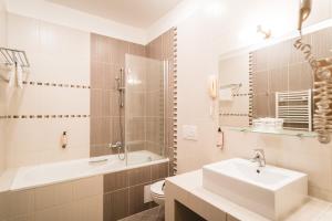 马汀图里克酒店的一间带水槽、浴缸和卫生间的浴室