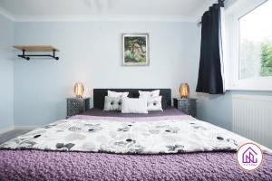 卡迪夫Luxury House, Swimming Pool, Hot Tub, Sauna的一间卧室配有一张大床和紫色毯子
