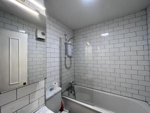 都柏林Riverside South Dublin City 2 bedroom的白色瓷砖浴室设有浴缸和卫生间。