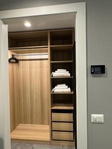 米兰阿拉卡萨迪吉奥公寓的步入式衣柜,配有木制橱柜和毛巾