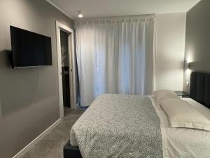 米兰阿拉卡萨迪吉奥公寓的一间卧室配有一张床和一台平面电视