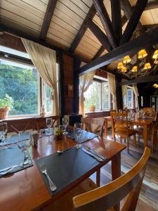 科伊艾科The Patagonian Lodge的用餐室设有木桌、椅子和窗户。