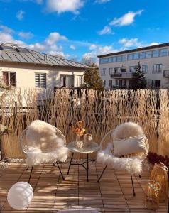 舍讷费尔德AMALFI HOME - Stylish apartment with terrace的庭院里设有两把椅子和一张桌子