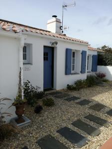 拉盖里尼耶尔nataliledeco bed and breakfeast的白色的房子,设有蓝色的门和庭院